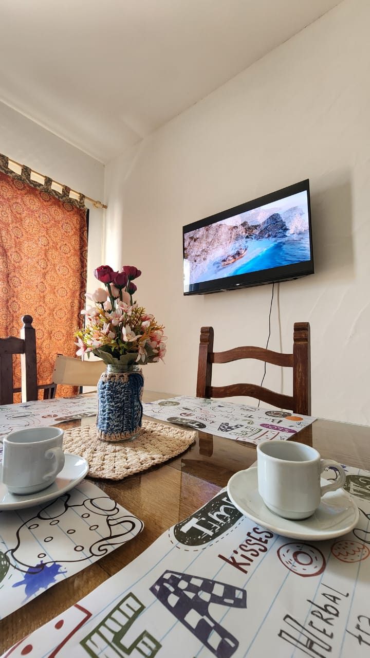La mesa del comedor puesta, con el televisor al fondo