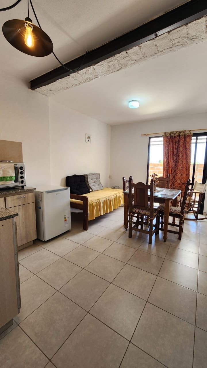 Living comedor con la cocina integrada y salida al balcón